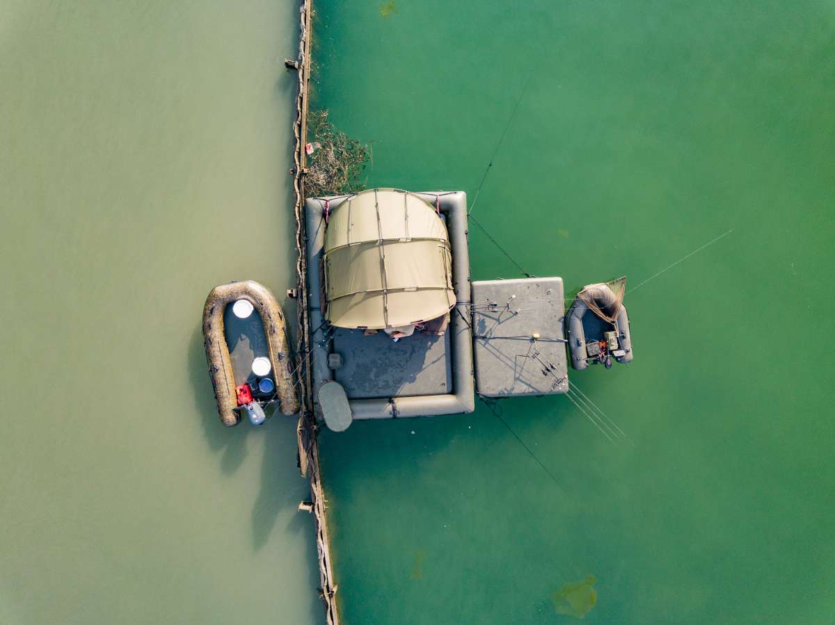 Raptor platform met rubberboot en bivvy op het water, drone-foto
